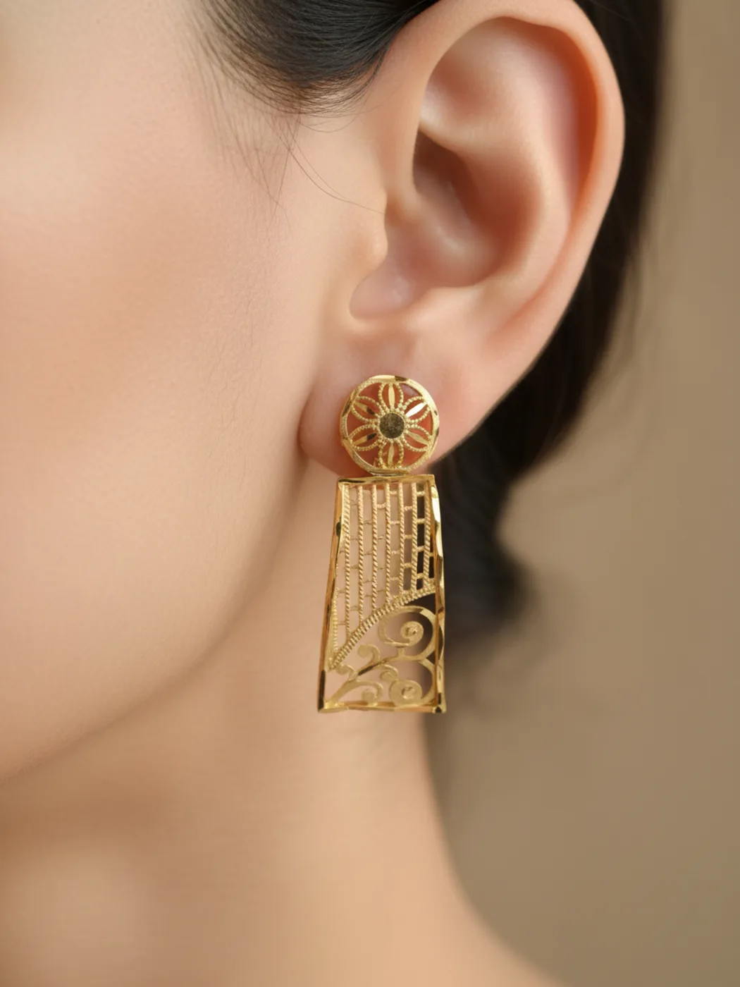Gold-plated filigree fan drop earring worn on a model’s ear