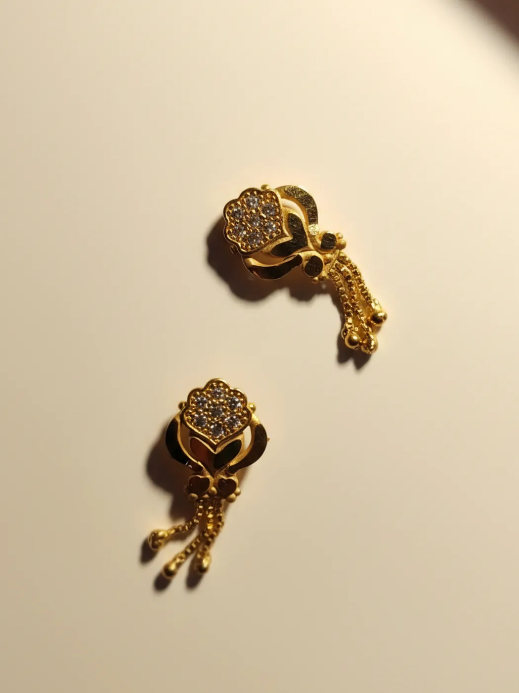 Gold-plated floral stud earrings with hanging tassel chains